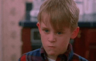 a young boy in a plaid shirt is making a face .