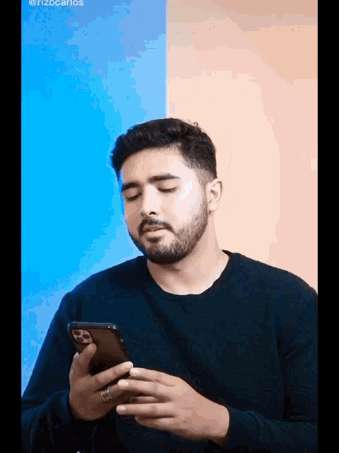 a man with a beard is holding a cell phone