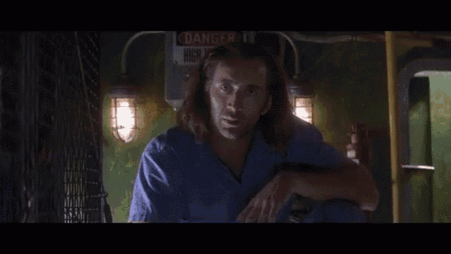 a man stands in front of a sign that says danger high