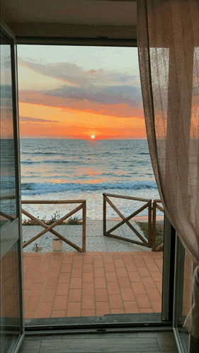 a view of a sunset over the ocean from a house