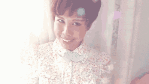 a woman wearing a floral shirt and a blue bow tie