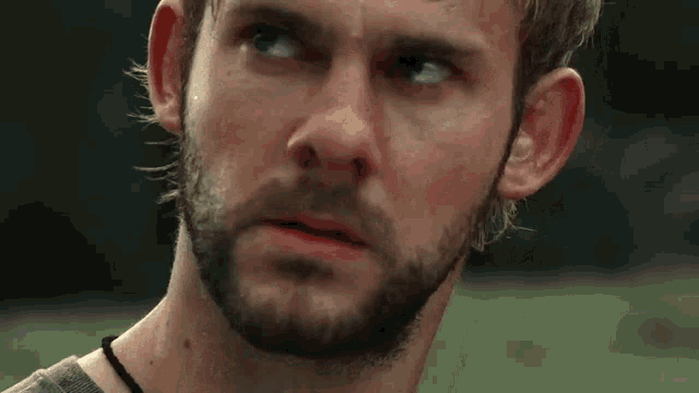 a close up of a man with a beard looking at the camera