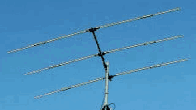 a large antenna is sitting in the middle of a clear blue sky .