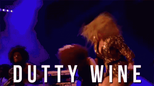 a woman is dancing on a stage with the words dutty wine written on the bottom .