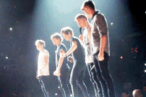 a group of men are standing on a stage with microphones in their hands