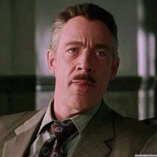 a man with a mustache and a suit and tie is making a funny face .