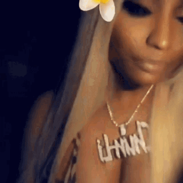 a close up of a woman wearing a necklace with the name nicki on it .