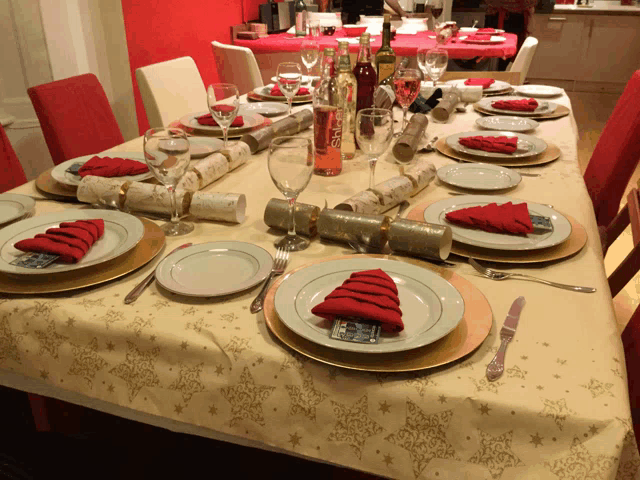 a table set for a christmas dinner with a bottle of evian wine on it