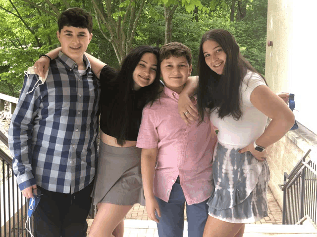 a group of young people posing for a picture with one girl wearing a blue lanyard