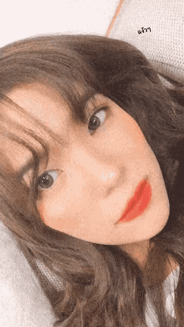 a close up of a woman 's face with a foreign language written on the bottom right