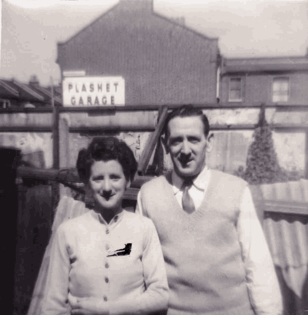 a man and a woman are posing in front of a sign that says flashet garage