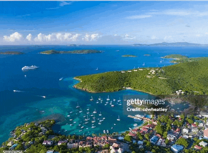 an aerial view of the islands of the british virgin islands with a cruise ship in the distance .