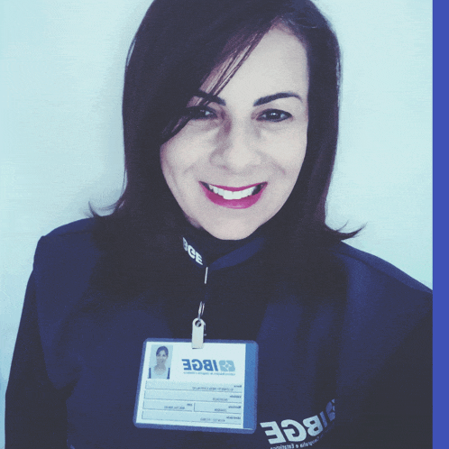 a woman wearing a badge that says ibge smiles for the camera