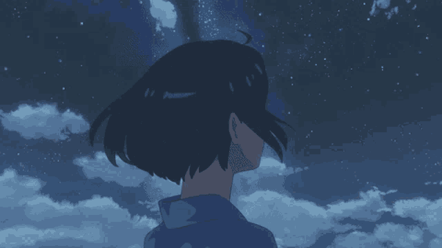 a girl in a blue shirt is looking up at the sky