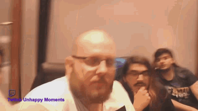 a man with glasses and a beard is looking at the camera with the words twitter unhappy moments written above him