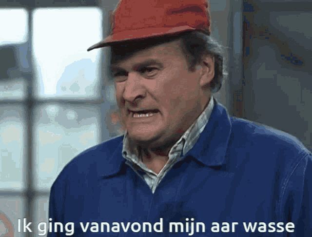 a man wearing a red hard hat and a blue jacket says ik ging vanavond mijn aar wasse