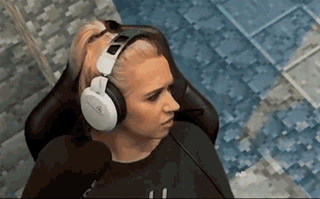 a woman is wearing headphones and sitting in a chair .