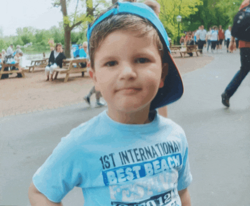 a young boy wearing a 1st international best beach shirt