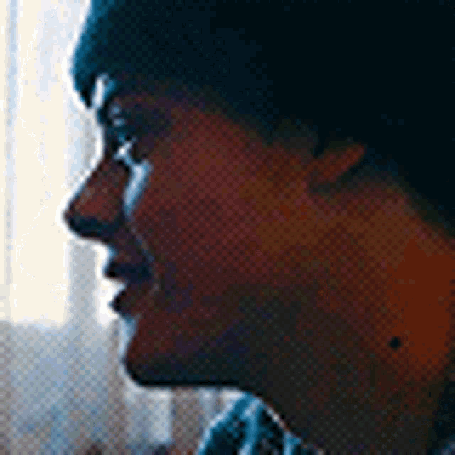 a close up of a person 's face with a black hat on .