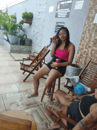 a woman sits in a chair in front of a sign that says ' piscina de acesso '