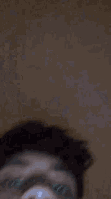 a close up of a young man 's face with a black spot on his forehead .