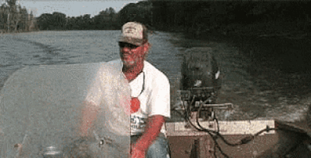 a man in a hat is sitting in a boat with a motor