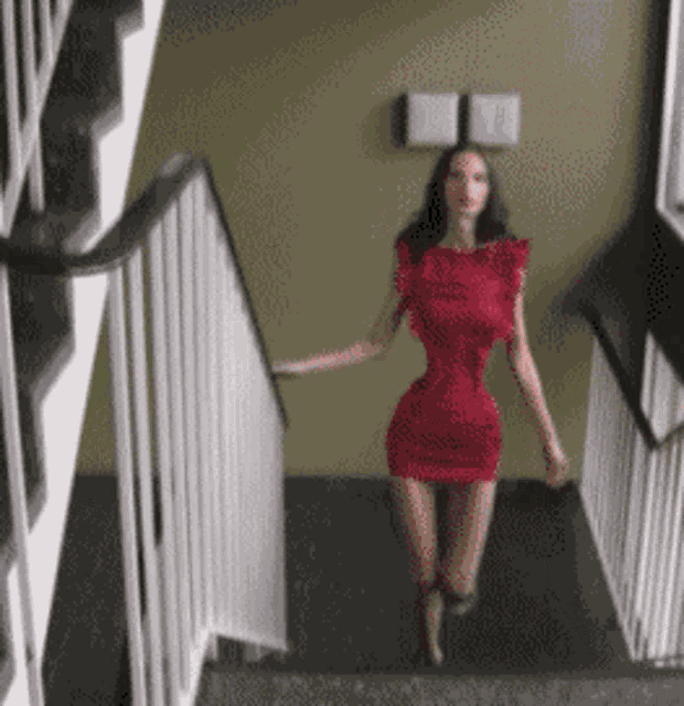 a woman in a red dress is walking down some stairs