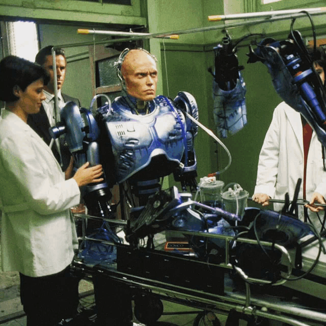 a group of people are working on a robot that says ' robocop ' on the chest