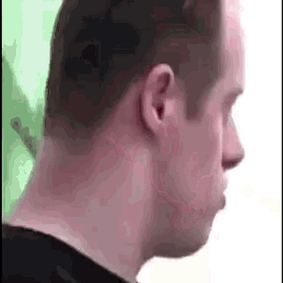 a close up of a man 's neck and ear with a green background .