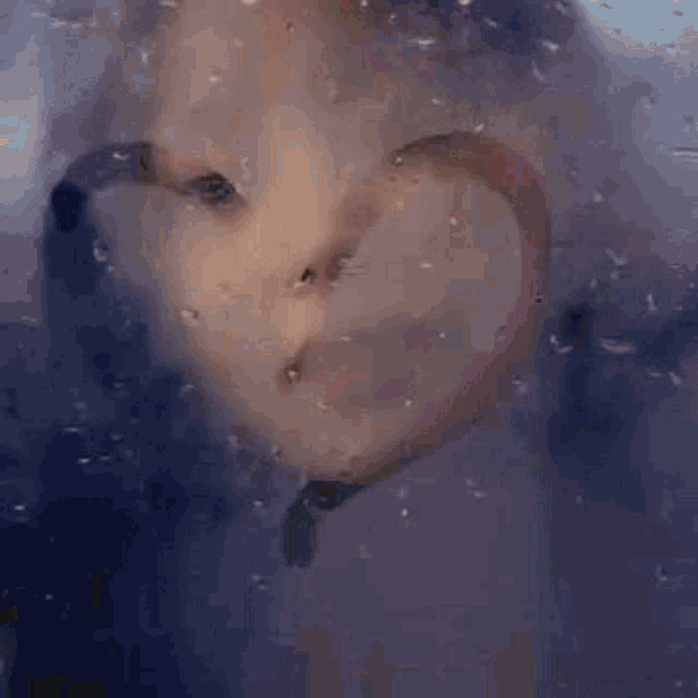 a close up of a woman 's face with a black object in front of her face .