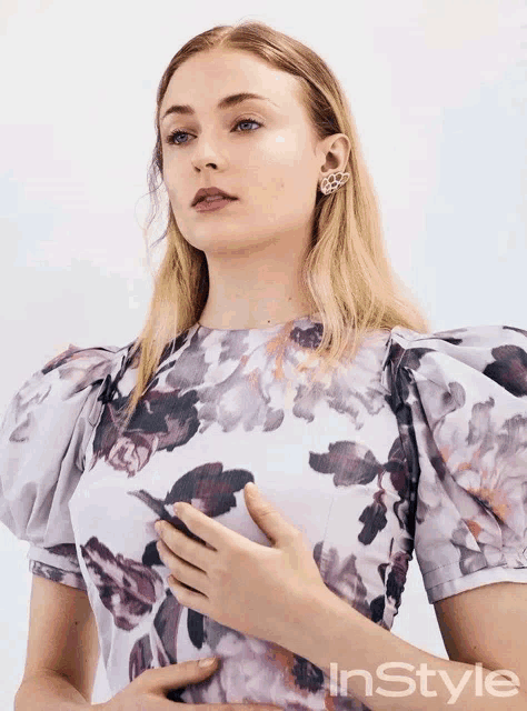 a woman wearing a floral dress is featured in instyle magazine