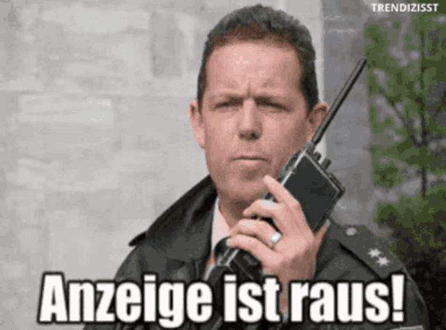 a man is holding a walkie talkie and says anzeige ist raus !