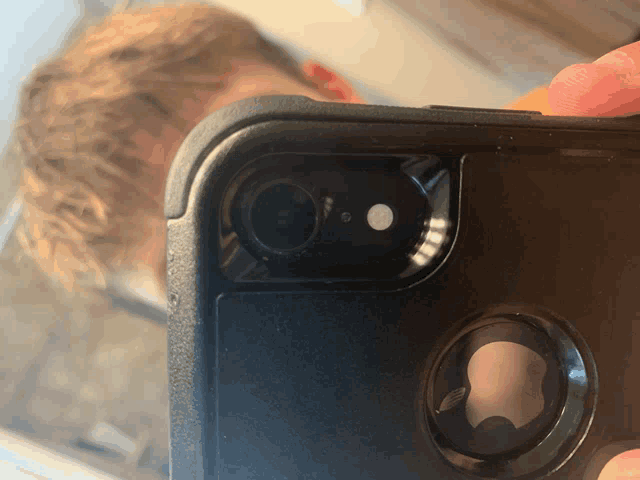 a close up of a person holding a phone with a camera on it