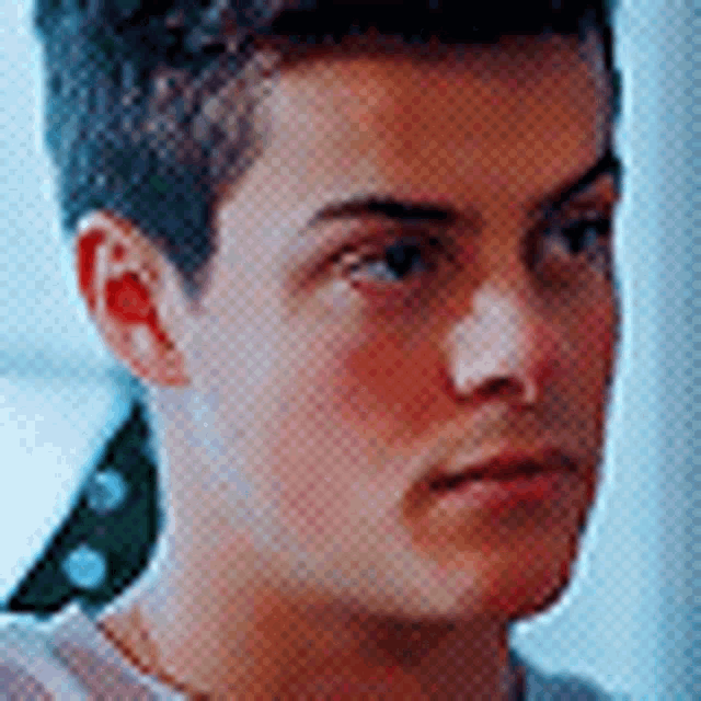 a close up of a young man 's face with a striped shirt on .