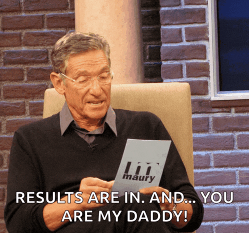 a man sits in a chair holding a piece of paper that says lil maury