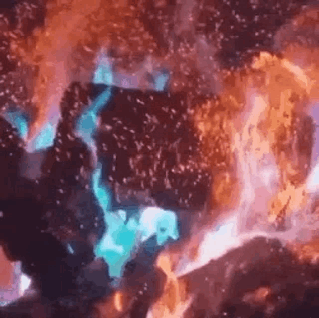 a close up of a fire with blue flames coming out of it