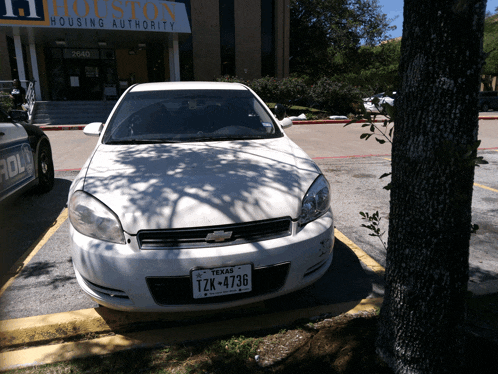 a white car is parked in front of the houston housing authority building