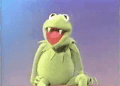 kermit the frog is sitting on a bench with his mouth open and his teeth showing .