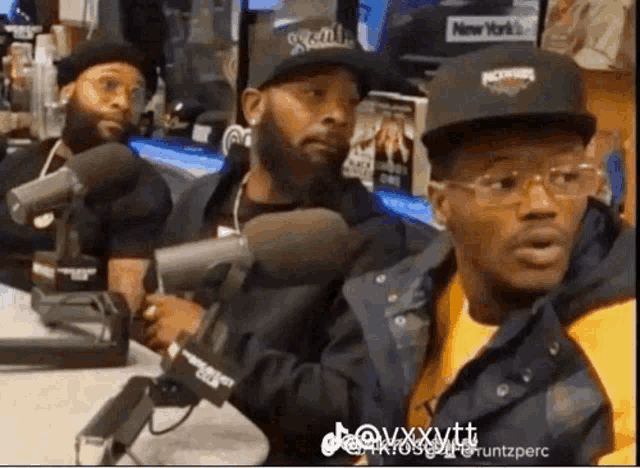 a group of men are sitting in front of microphones and one of them is wearing a hat that says rockwell on it