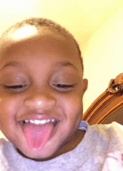 a young boy is sticking his tongue out while smiling