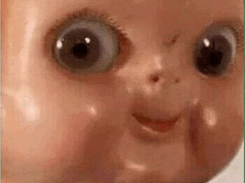 a close up of a creepy doll 's face with big eyes .