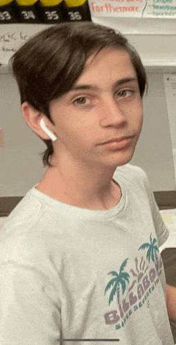 a young man wearing a white billabong t-shirt