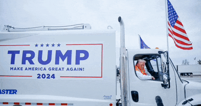 a man driving a truck that says trump on the side