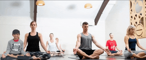 a boy wearing a fila shirt sits in a lotus position