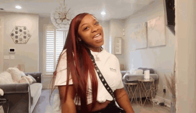 a woman with red hair is wearing a white t-shirt that says ' t-shirt ' on it