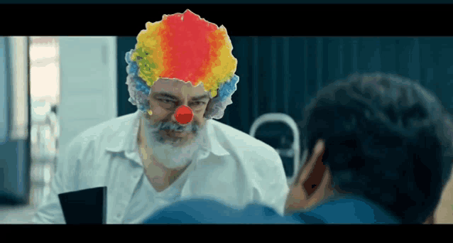 a man with a beard wearing a clown wig and red nose talks to another man .