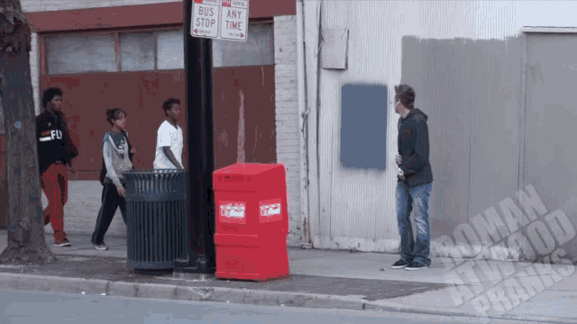 a man standing next to a red box that says coca cola on it