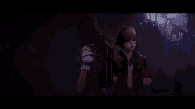 a man and a woman are standing next to each other in a dark room .