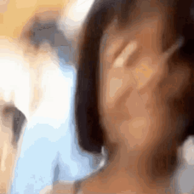 a blurry photo of a woman covering her face with her hand