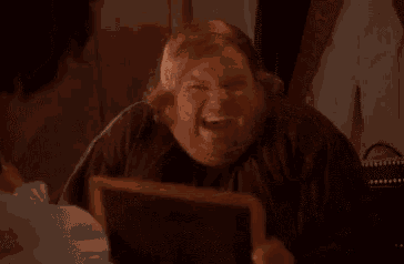 a fat man is looking at himself in a mirror and smiling .